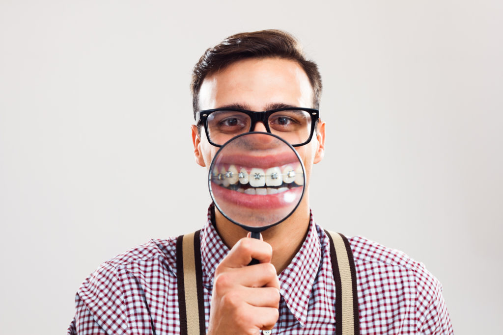 Man with Magnifying Glass On Braces